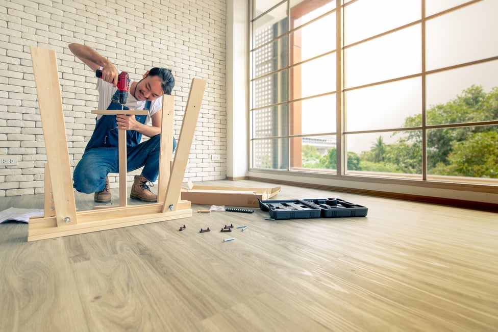 Handyman is assembling table.